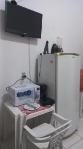 a table with a microwave and a chair in a kitchen at Aluguel de loft mobiliado em Cuiabá in Cuiabá +6 photos