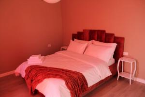 a bedroom with a large bed with red walls at Sunny Home overlooking Tirana in Tirana