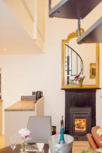 a dining room with a fireplace and a mirror at Ladyston Barn in Muthill
