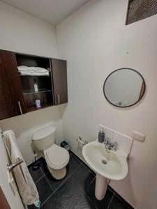 y baño con aseo, lavabo y espejo. en Apartamento Duplex en ubicacion privilegiada, en Manizales