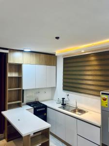 a kitchen with white cabinets and a sink at Ten heads in Tema