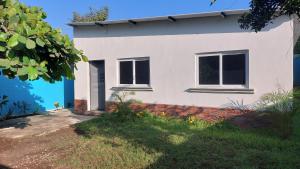 a white house with a blue at Casa de descanso Grace in San José de Guatemala