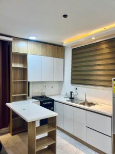 a kitchen with white cabinets and a sink at Ten heads in Tema