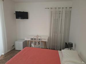 a bedroom with a bed and a desk and a television at AL Penaferrim Sintra Rooms in Sintra +59 photos