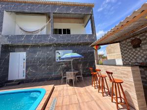een terras met een tafel en stoelen en een zwembad bij Bela Beach in São José da Coroa Grande