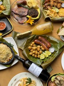 una mesa cubierta con platos de comida y una botella de vino en Termales Wellness Hotel, en Bogotá