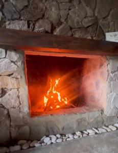 Un horno de piedra con fuego. en Los Helechos 5M, en Jarabacoa