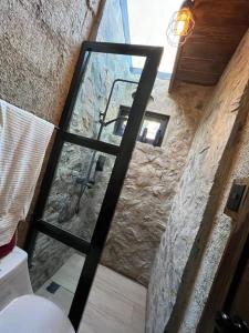 una puerta de cristal en una habitación con una pared de piedra en Los Helechos 5M, en Jarabacoa