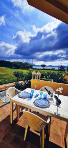 - une table et des chaises sur une terrasse avec vue sur l'océan dans l'établissement Appartamenti delfini terza spiaggia, à Golfo Aranci