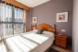 een slaapkamer met een groot bed en een raam bij Apartamento familiar centrico in Denia +18 foto's