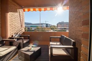 een balkon met banken en uitzicht op de stad bij Apartamento familiar centrico in Denia