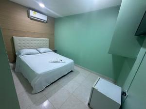 een slaapkamer met een wit bed in een kamer bij HOTEL NUEVO ARIZONA in Cartagena