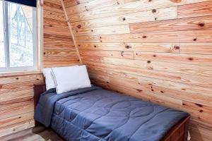 um quarto com uma cama numa parede de madeira em A is for A-Frame em Dandridge