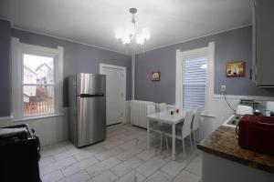 a kitchen with a table and a stainless steel refrigerator at Renovated Brady St. Classic in Milwaukee