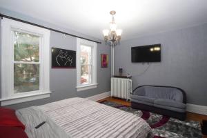 a bedroom with a bed and a chair and a television at Renovated Brady St. Classic in Milwaukee