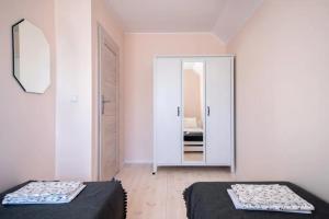 two beds in a room with a mirror at Domek A 145 Miód Malina- Kaszubska Ostoja in Barkocin