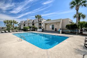 默特爾海灘的住宿－Stay Salty，棕榈树建筑前的游泳池