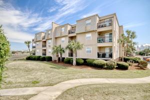 a large apartment building with palm trees and a sidewalk at Stay Salty in Myrtle Beach