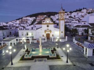 a large white building with a clock tower in a town at Aires de Grazalema in Prado del Rey