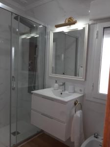 uma casa de banho branca com um lavatório e um chuveiro em Aires de Grazalema em Prado del Rey
