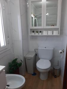 een badkamer met een toilet, een wastafel en een spiegel bij Aires de Grazalema in Prado del Rey