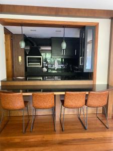 uma cozinha com uma mesa e três cadeiras em Apartamento em canela em Canela