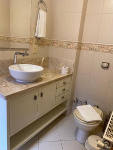 uma casa de banho com um lavatório e um WC em Apartamento em canela em Canela