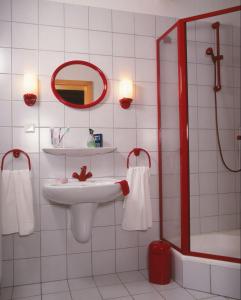 a white bathroom with a sink and a mirror at Pension Zumpe in Stolpen