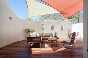 een patio met een tafel en stoelen en een parasol bij Casa Azahar in Níjar