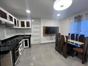 a kitchen with a table and a tv in it at Papillo Tower in Bayahibe