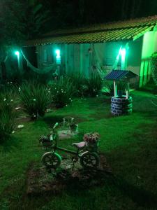 a bike parked in the yard of a house at night at Pousada Recanto dos Arcos in Conservatória