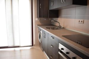 een keuken met een wastafel en een wasmachine bij Apartamento Carteya in Algeciras