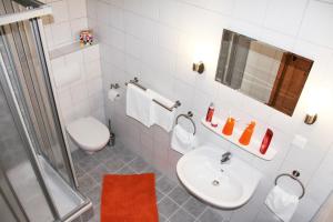 a white bathroom with a sink and a toilet at Pension Zumpe in Stolpen