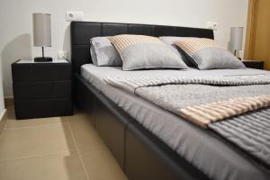 een bed met een zwart hoofdeinde en kussens erop bij Apartamento Carteya in Algeciras
