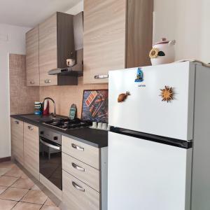 a kitchen with a white refrigerator with magnets on it at Villa Genesia in Bacoli