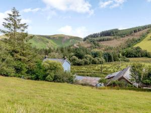 a field with a house in the middle of a hill at 1 Bed in Builth Wells BN029 in Llanafan-fawr