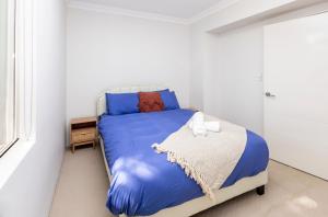 a bedroom with a blue bed in a white room at Urban Retreat Townhouse near CBD in Perth