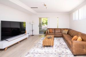 a living room with a couch and a large flat screen tv at Urban Retreat Townhouse near CBD in Perth