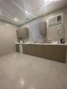 a large kitchen with a sink and a microwave at شقق فندقيه فاخره بتصمم عصري ودخول ذاتي in Jeddah