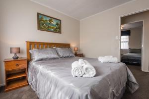 ein Schlafzimmer mit einem Bett mit Handtüchern darauf in der Unterkunft Beez Kneez in Rotorua