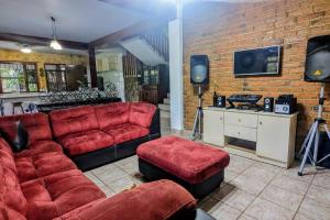 a living room with red furniture and a brick wall at The Guamacaya House in Copan Ruinas