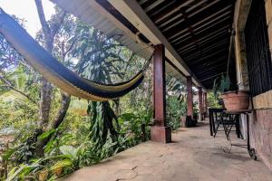 a porch of a house with a hammock on it at The Guamacaya House in Copán Ruinas