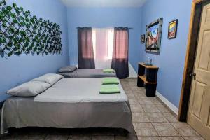 2 camas en una habitación con paredes azules en The Guamacaya House, en Copan Ruinas