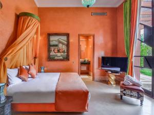 - une chambre avec un grand lit et une télévision dans l'établissement Villa Soraya/Noor Hotel & Spa, à Marrakech