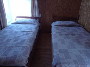two beds in a small room with a window at Departamento Erica 2 in Panguipulli