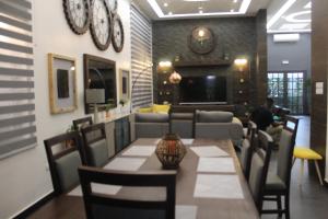 a restaurant with a table and chairs and a living room at Libdo Immos in Cotonou