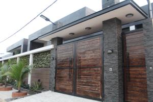 a house with wooden garage doors at Libdo Immos in Cotonou