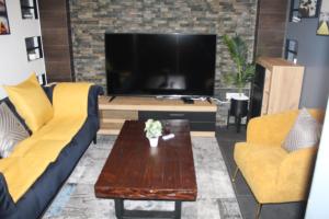 a living room with two couches and a tv at Libdo Immos in Cotonou