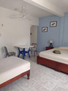 Pokój z 2 łóżkami, stołem i krzesłami w obiekcie Las Palapas de Punta Allen w mieście Punta Allen