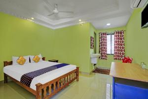 a bedroom with a bed with green walls at OYO Hotel SS Residency in Punalūr